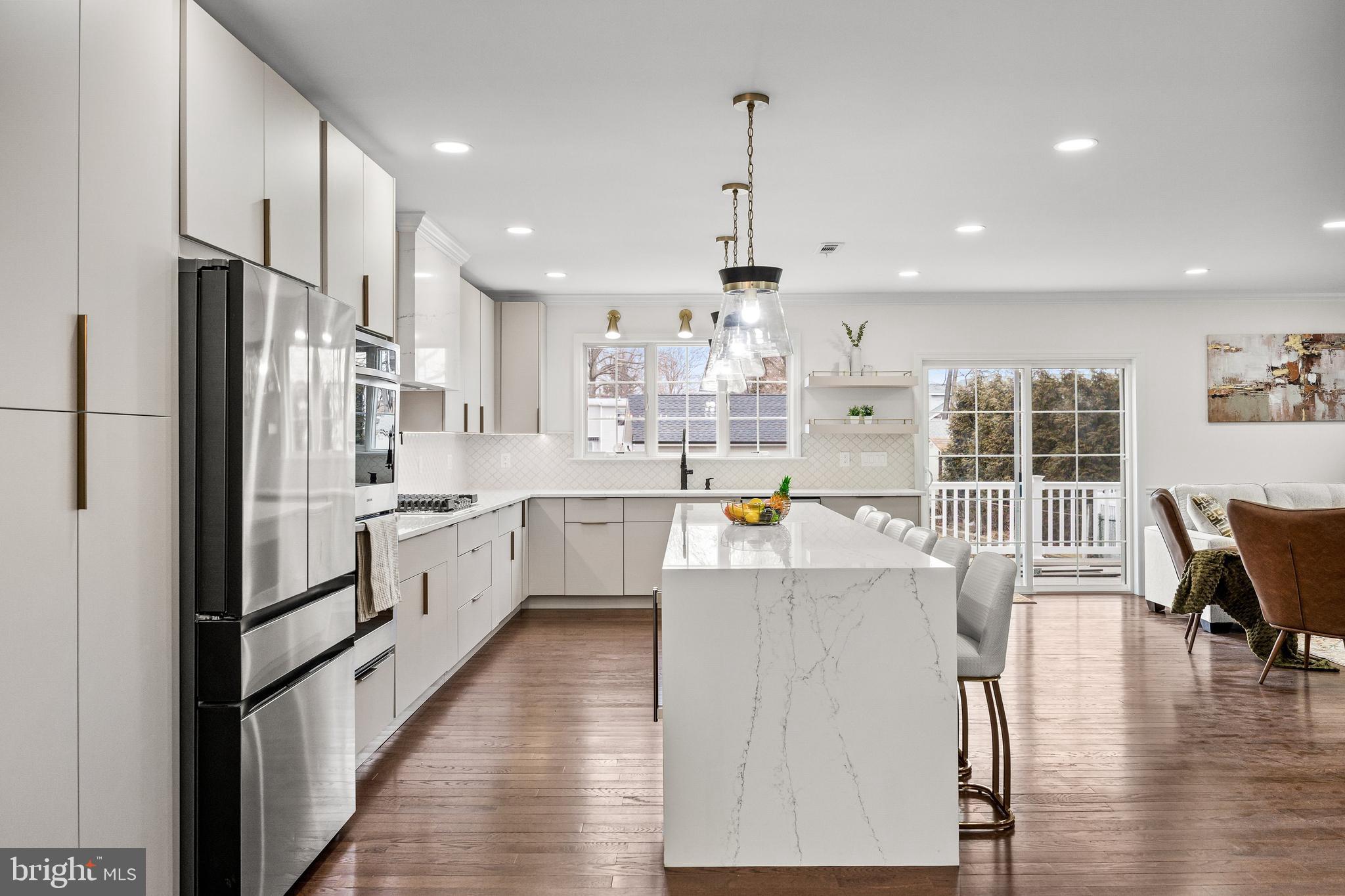 15 Cuthbert Boulevard Haddon Township, NJ 08107 - Photo 25 of 60 a large kitchen with stainless steel appliances kitchen island granite countertop a large kitchen island a stove a refrigerator a sink a dining table and chairs with wooden floor