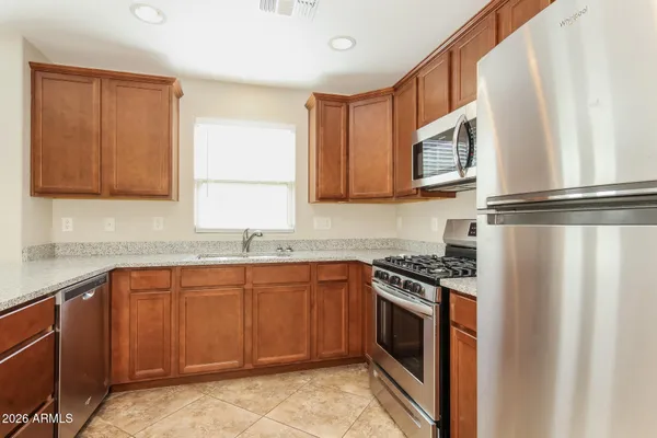 a kitchen with stainless steel appliances granite countertop a stove a sink and a microwave
