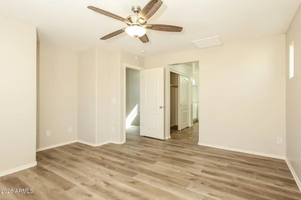 a view of a room with wooden floor and a ceiling fan