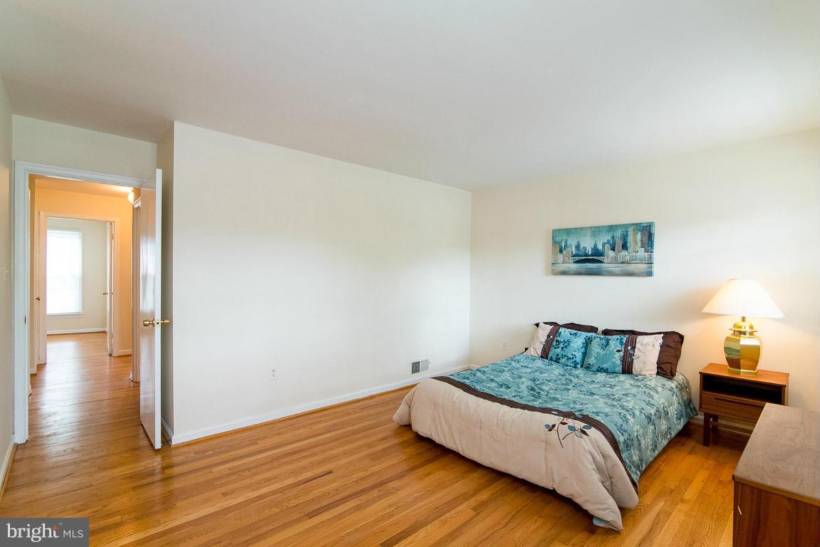 1203 Gresham Road Silver Spring, MD 20904 - Photo 22 of 30 a bedroom with a bed and wooden floor