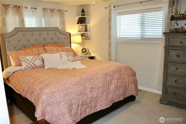 a large bed sitting in a bedroom next to a window
