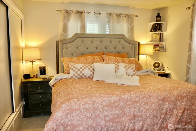 a large bed sitting in a bedroom next to a lamp