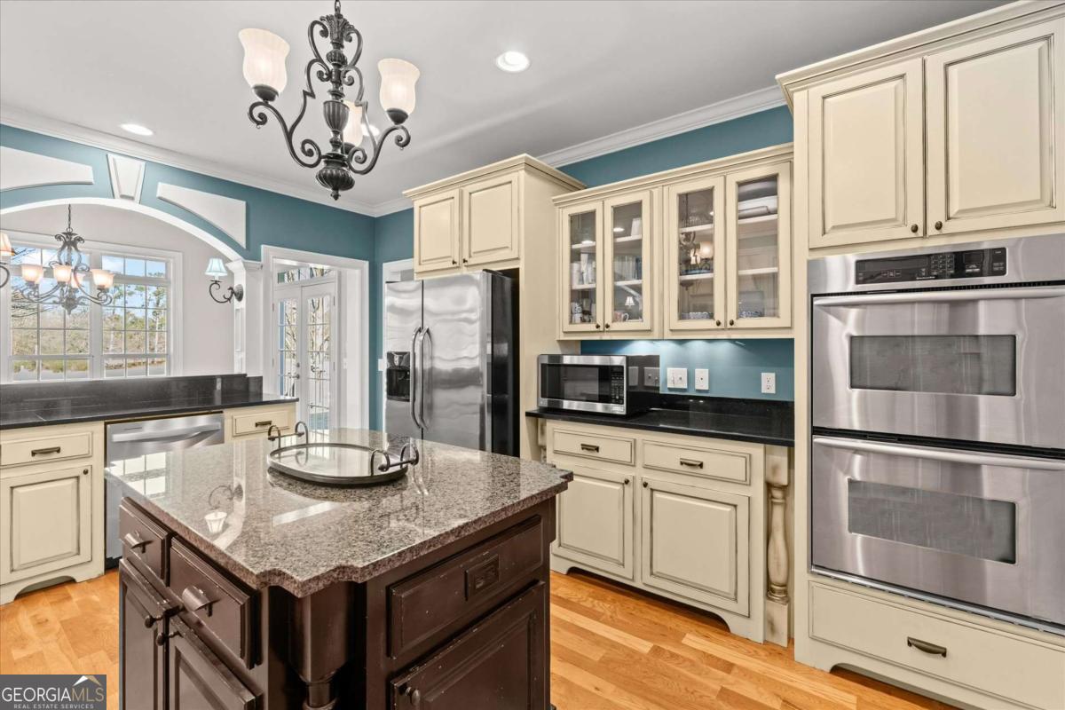 220 McKenzie Bridge Road Carrollton, GA 30117 - Photo 18 of 80 a kitchen with stainless steel appliances granite countertop a kitchen island hardwood floor and a window