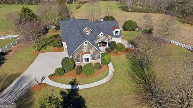 a view of a big house with a big yard and large trees