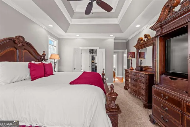 a bedroom with a large bed and a chandelier