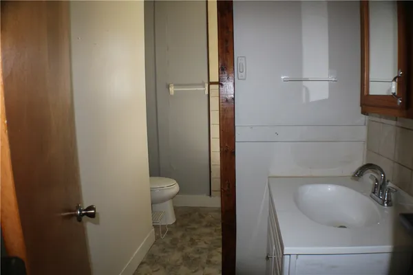 a bathroom with a granite countertop toilet sink and mirror