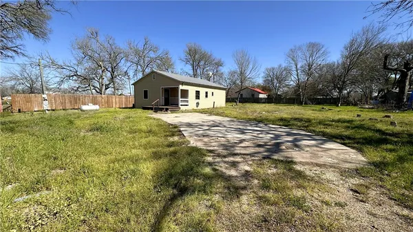 a front view of a house with a yard and trees