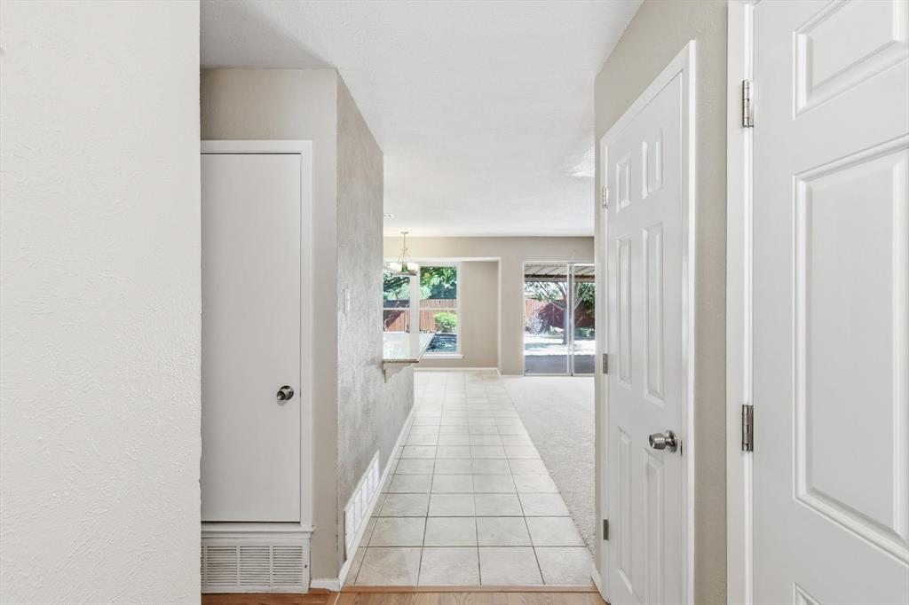 425 Ridgecrest Drive Saginaw, TX 76179 - Photo 7 of 27 a view of a hallway with white walls and wooden floor