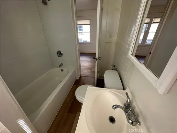 a bathroom with a tub sink and mirror