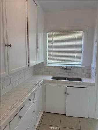 a kitchen with granite countertop white cabinets and a sink