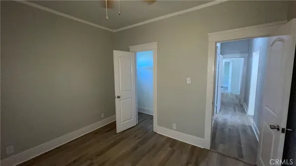 an empty room with wooden floor and entrance