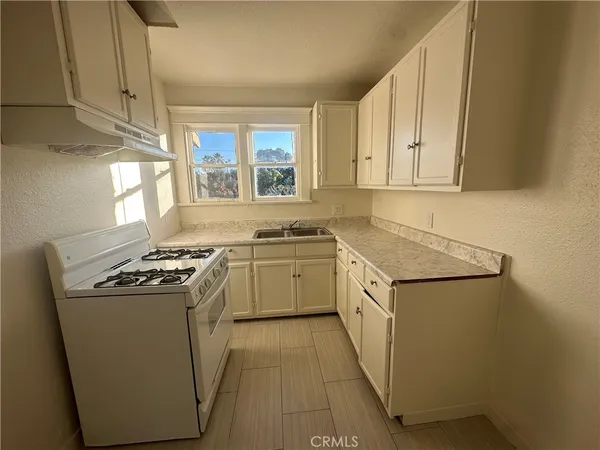 a kitchen with a stove sink and cabinets