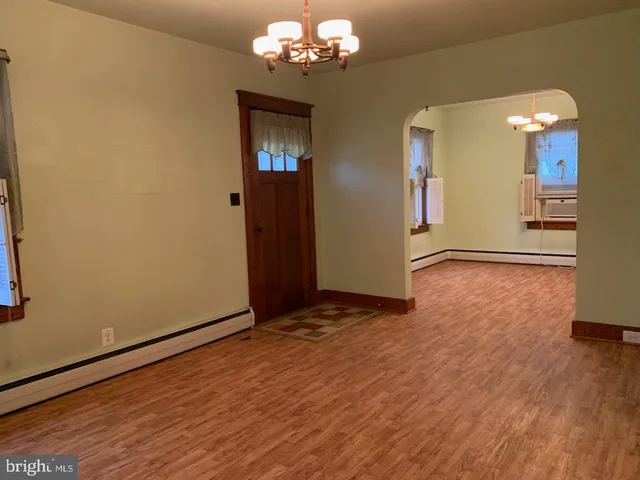 a view of a hallway with wooden floor and closet