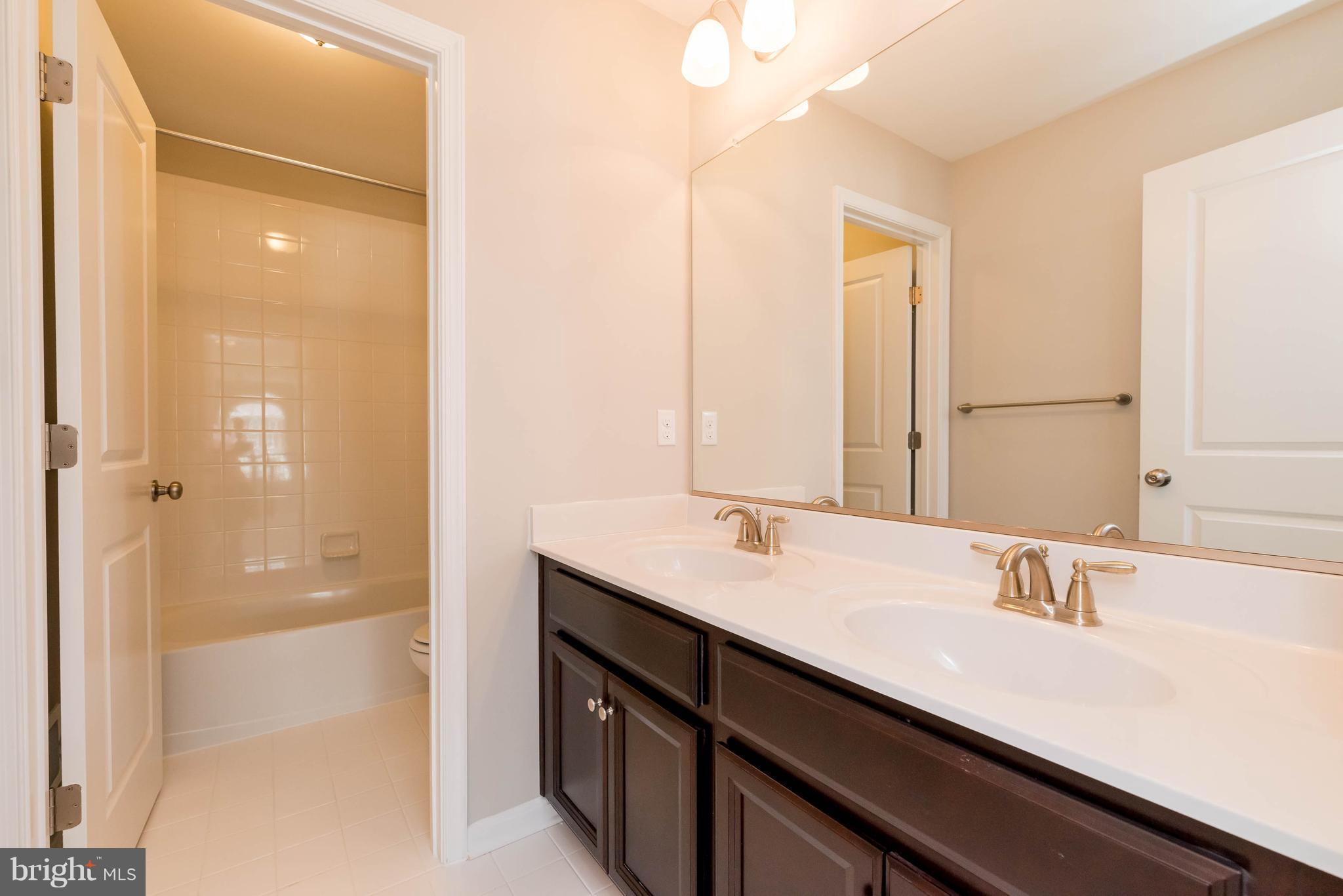 4229 Perry Hall Road Perry Hall, MD 21128 - Photo 20 of 30 a bathroom with a double vanity sink a mirror and a shower