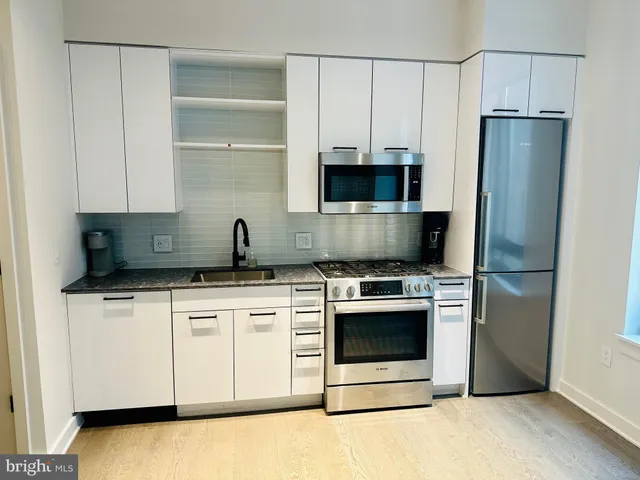 a kitchen with stainless steel appliances a stove a microwave and a refrigerator