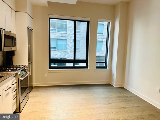 a view of a kitchen with stainless steel appliances wooden floor and a window
