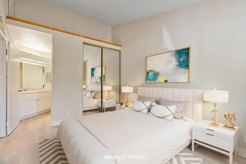 a bedroom with a bed and a painting on the wall