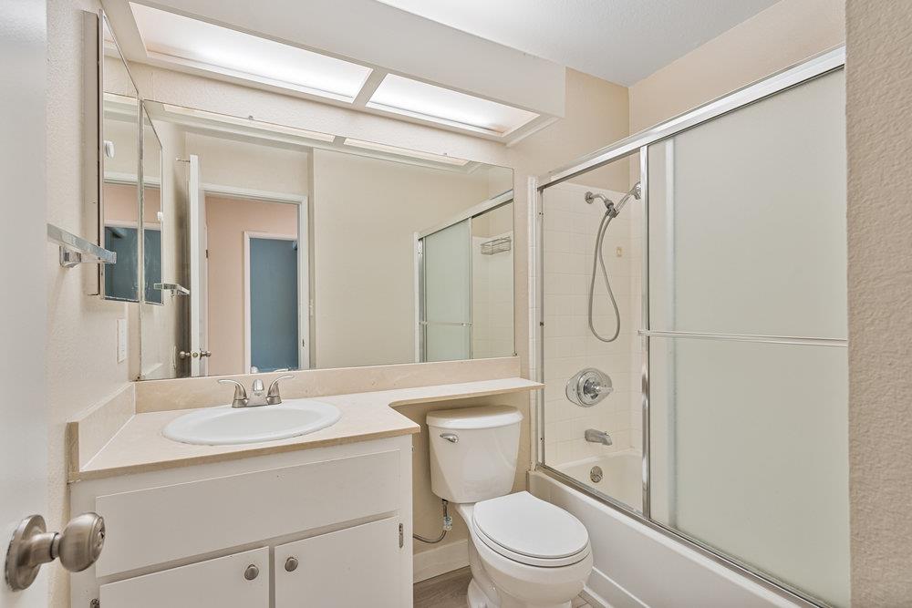 331 Shadow Run Drive San Jose, CA 95110 - Photo 17 of 25 a bathroom with a granite countertop sink toilet a mirror a shower and vanity