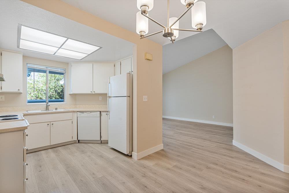 331 Shadow Run Drive San Jose, CA 95110 - Photo 10 of 25 a kitchen with kitchen island white cabinets and wooden floor