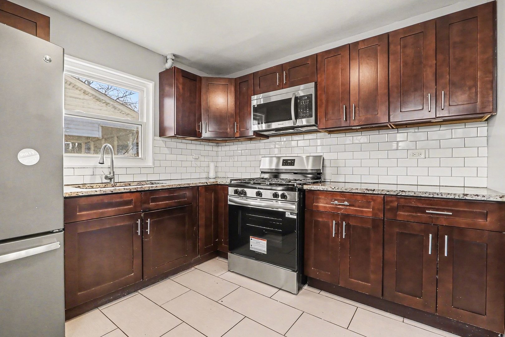 2817 173rd Street Hazel Crest, IL 60429 - Photo 4 of 23 a kitchen with stainless steel appliances granite countertop stove top oven microwave and cabinets