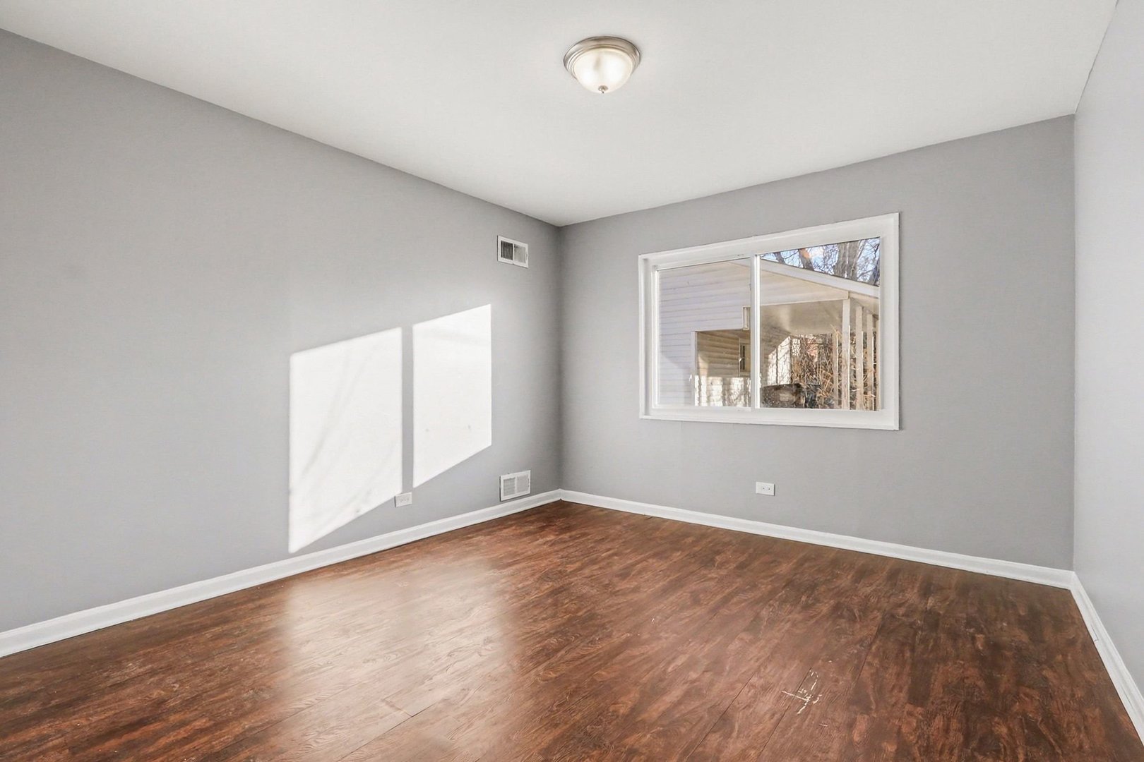 2817 173rd Street Hazel Crest, IL 60429 - Photo 10 of 23 an empty room with wooden floor and windows