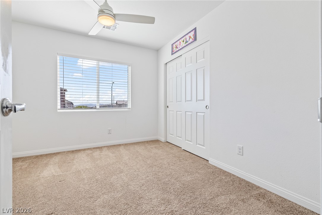 5510 Ripple Ridge Avenue Las Vegas, NV 89139 - Photo 35 of 45 This bright bedroom features soft carpeting, a ceiling fan, and a convenient closet.