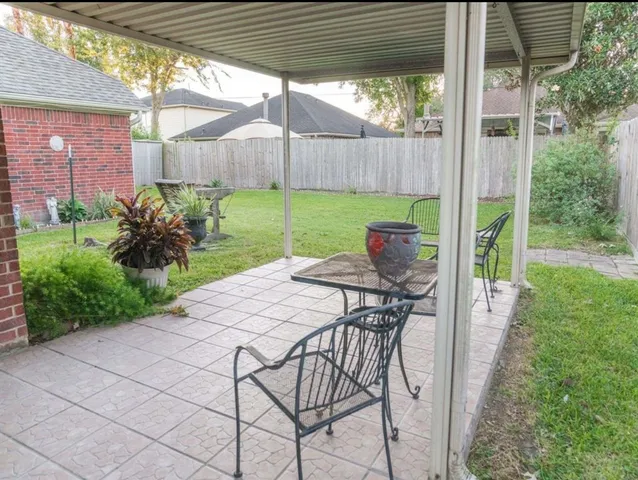 a patio with a table and chairs and potted plants