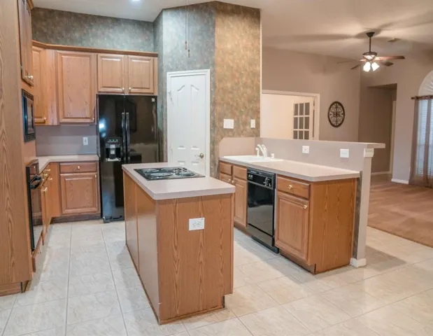 a kitchen with kitchen island stainless steel appliances a sink stove and refrigerator
