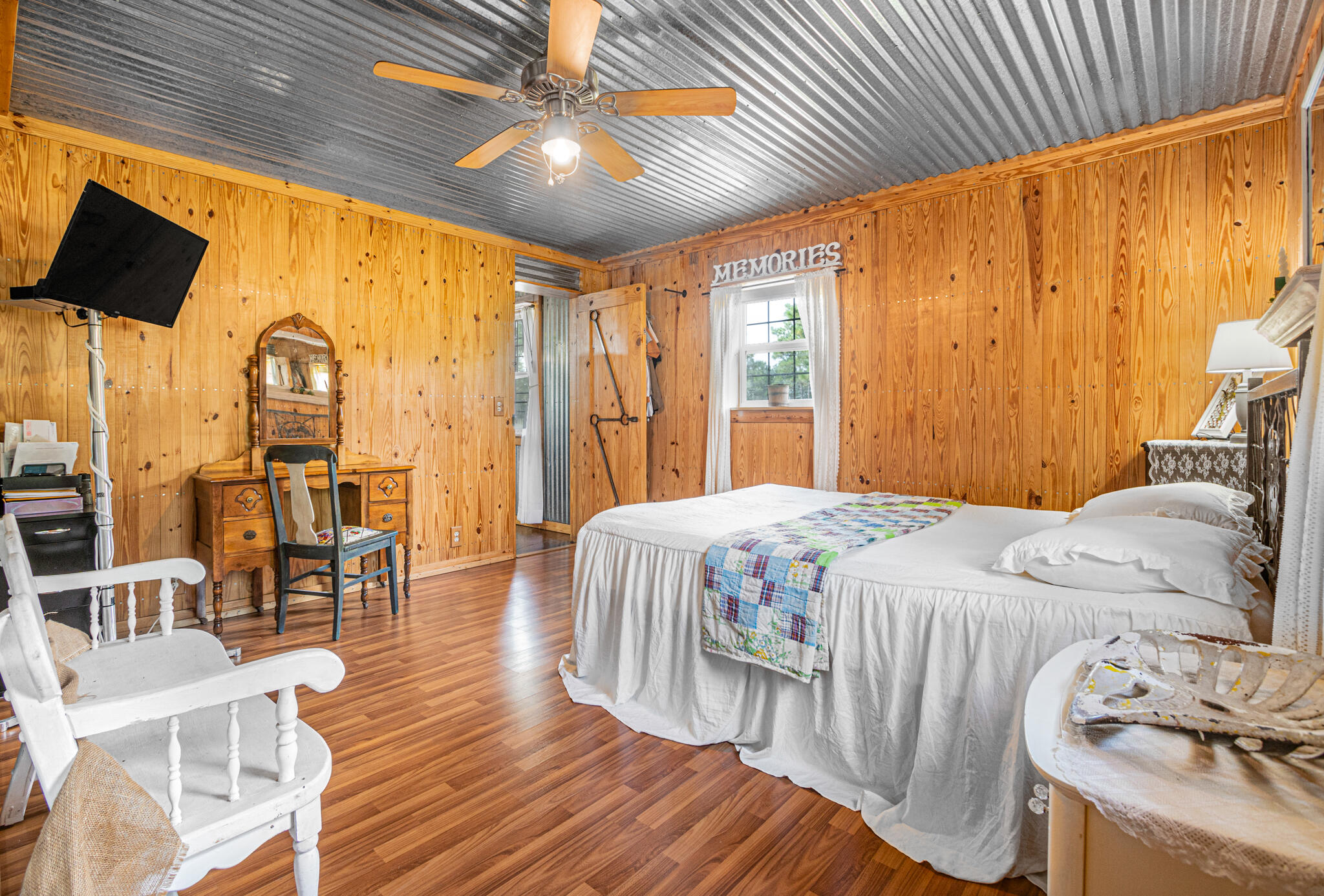 5263 Coy Burgess Loop DeFuniak Springs, FL 32435 - Photo 16 of 57 a bedroom with a bed a chandelier and next to a window
