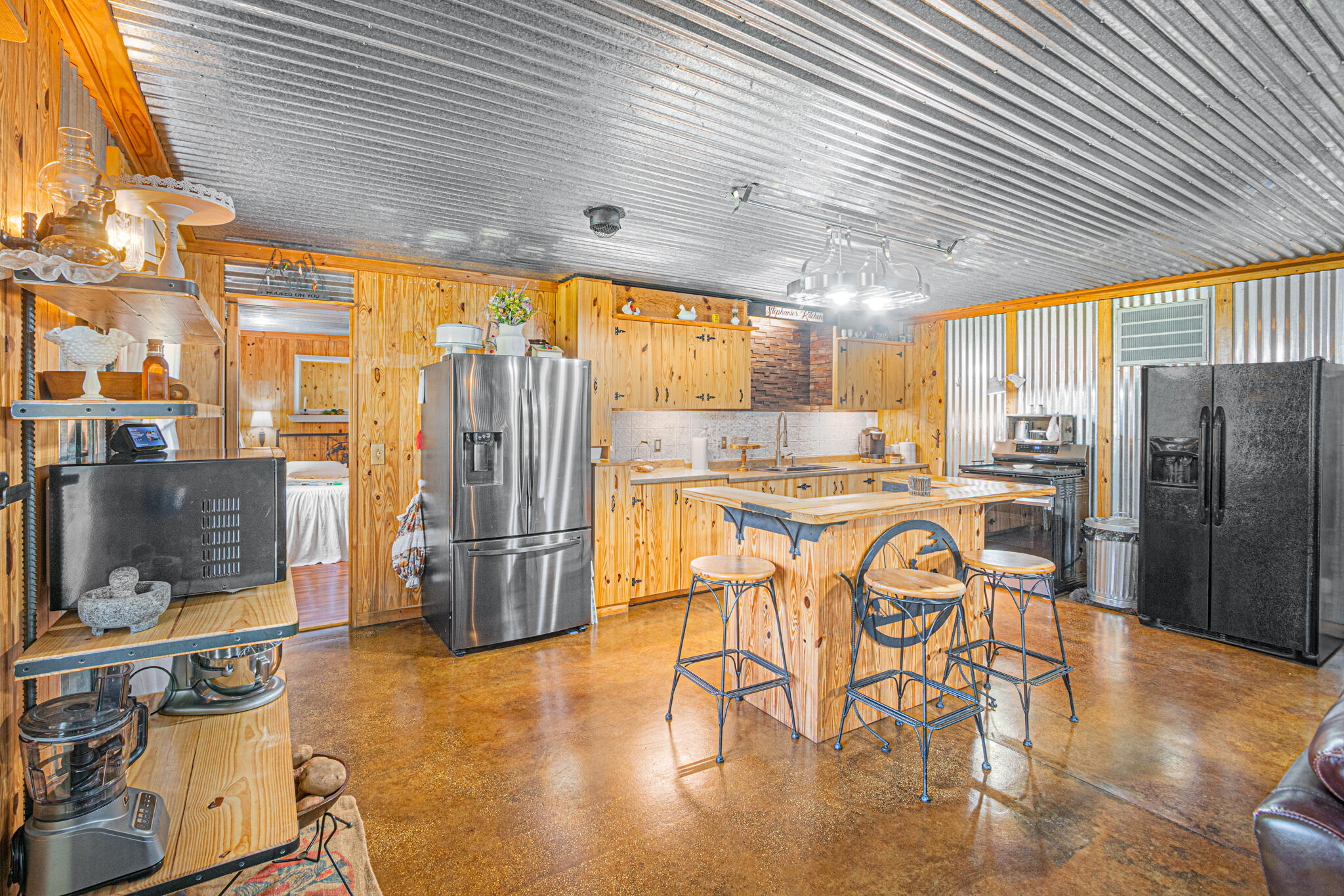 5263 Coy Burgess Loop DeFuniak Springs, FL 32435 - Photo 6 of 57 a kitchen with stainless steel appliances granite countertop a table chairs refrigerator and sink