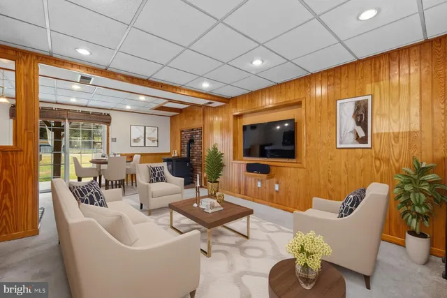 a living room with furniture kitchen view and a large window