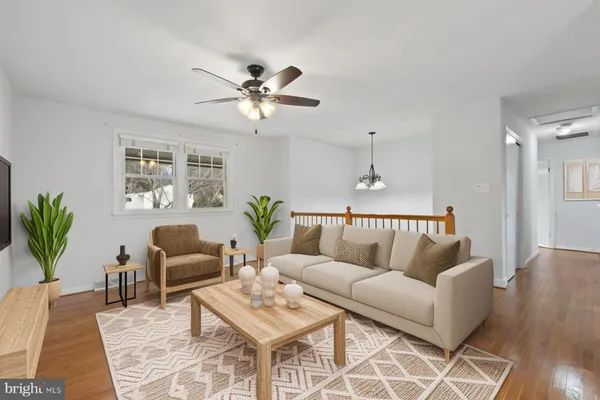 a living room with furniture a chandelier and a rug