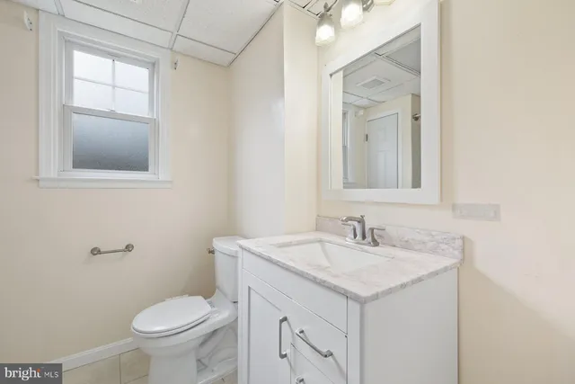 a bathroom with a sink toilet and mirror
