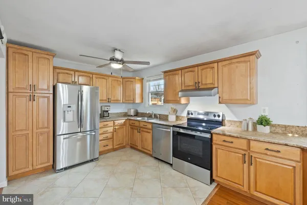 a kitchen with stainless steel appliances granite countertop a refrigerator sink and stove