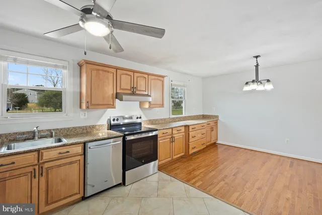 a kitchen with stainless steel appliances granite countertop a sink dishwasher stove and refrigerator