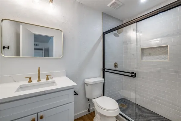 a bathroom with a sink a toilet and shower