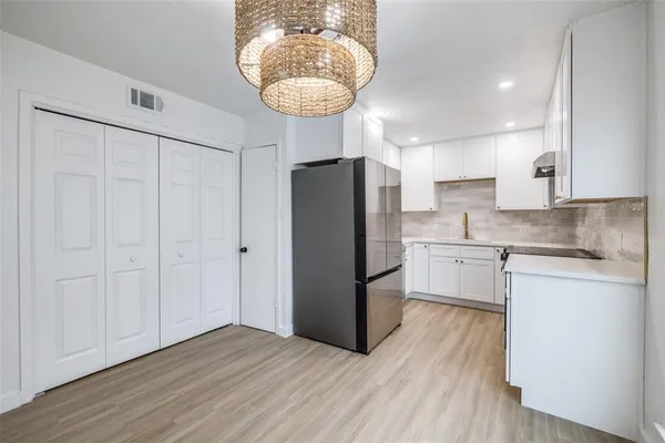 a kitchen with stainless steel appliances granite countertop white cabinets sink and dishwasher