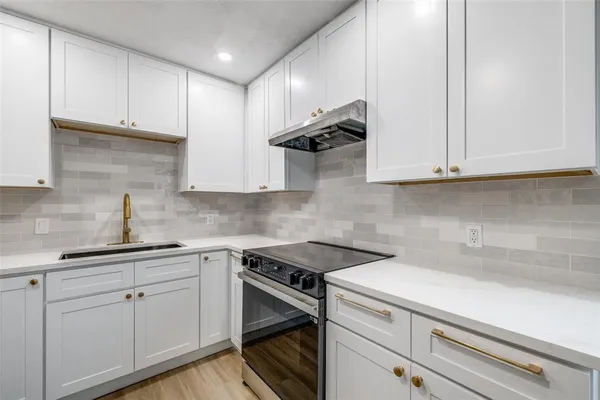 a kitchen with a refrigerator sink and cabinets