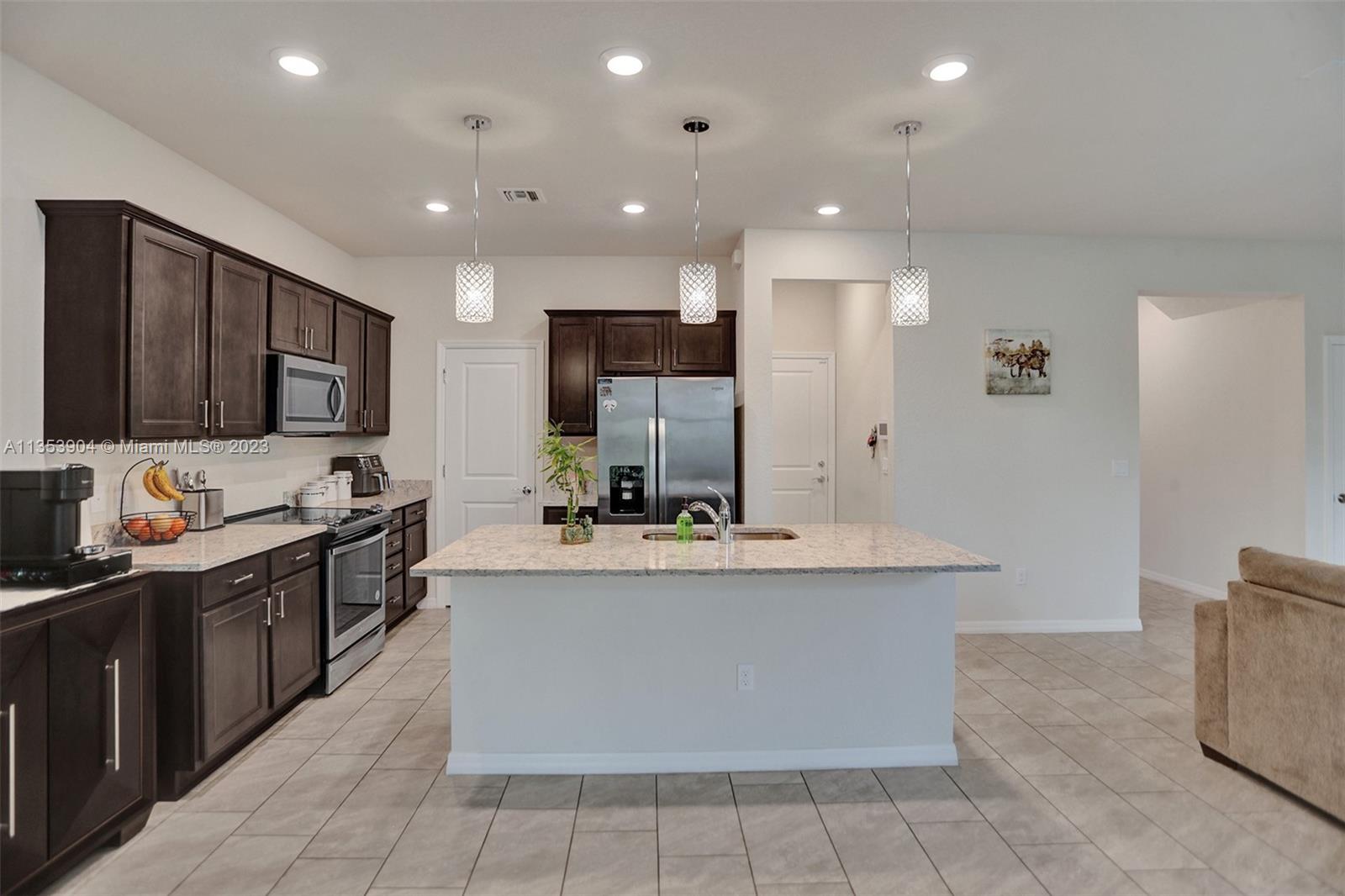 4764 Eucalyptus Drive, Unit 4764 Hollywood, FL 33021 - Photo 11 of 54 a large kitchen with stainless steel appliances a stove a sink dishwasher and a refrigerator