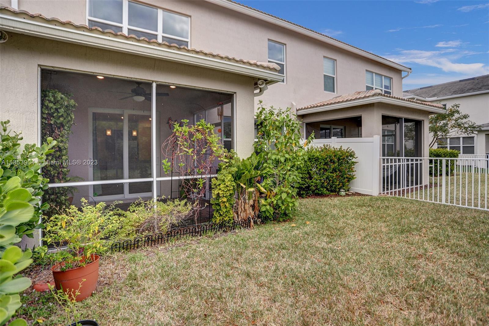 4764 Eucalyptus Drive, Unit 4764 Hollywood, FL 33021 - Photo 20 of 54 a view of a white house with large windows and flower plants