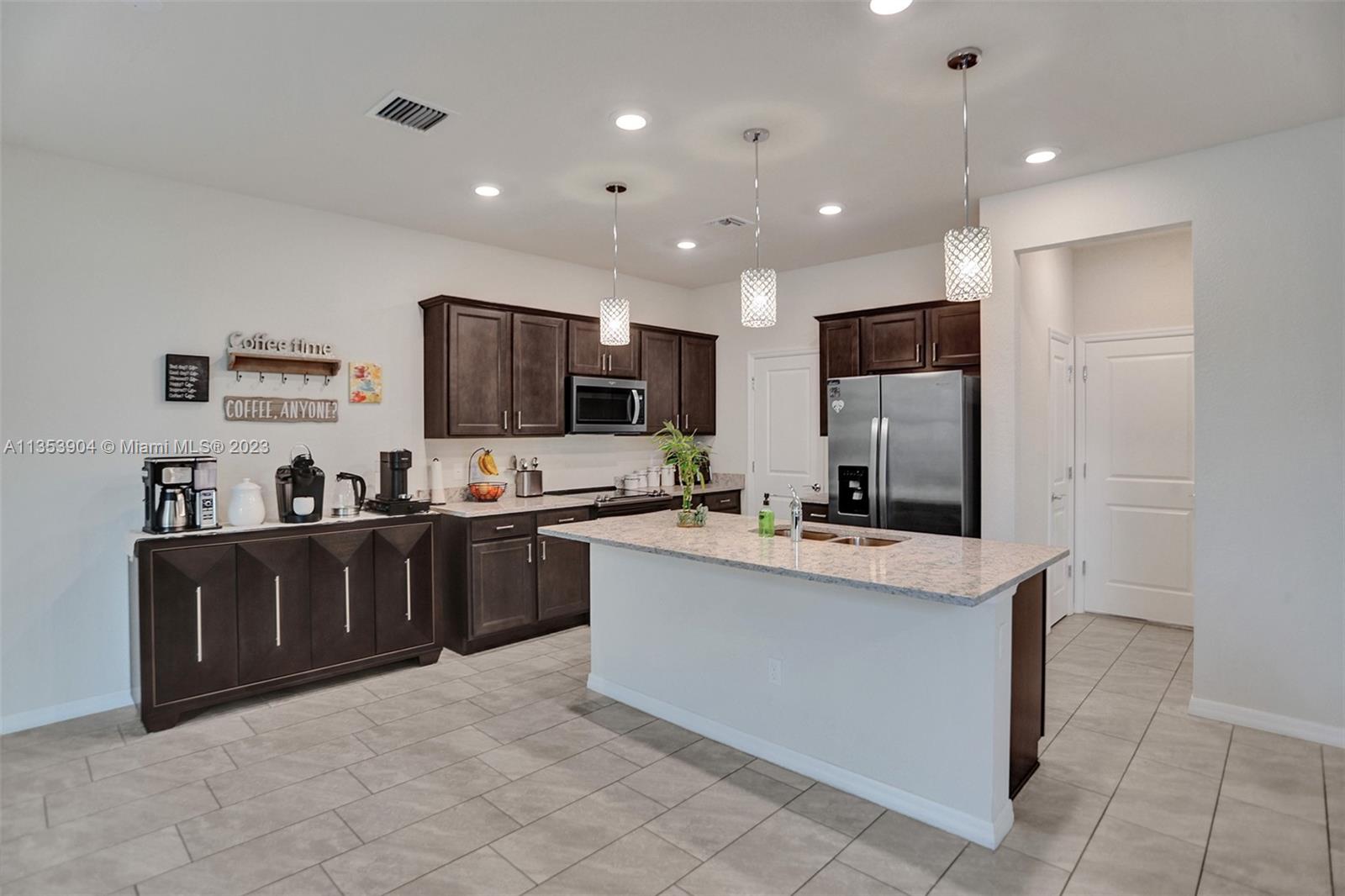 4764 Eucalyptus Drive, Unit 4764 Hollywood, FL 33021 - Photo 7 of 54 a large kitchen with kitchen island a sink appliances and cabinets