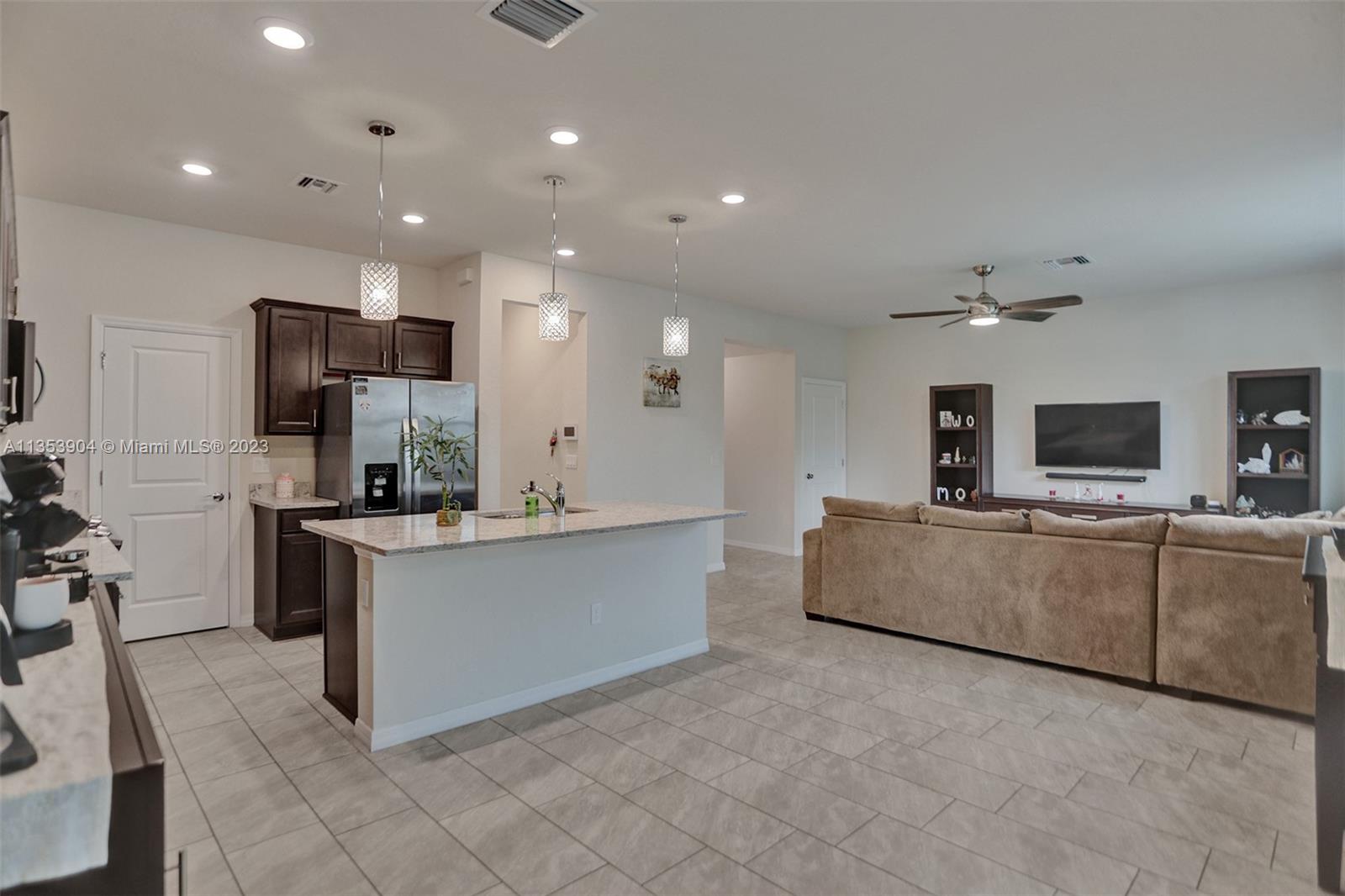 4764 Eucalyptus Drive, Unit 4764 Hollywood, FL 33021 - Photo 8 of 54 a large living room with stainless steel appliances kitchen island granite countertop a couch and a view of living room