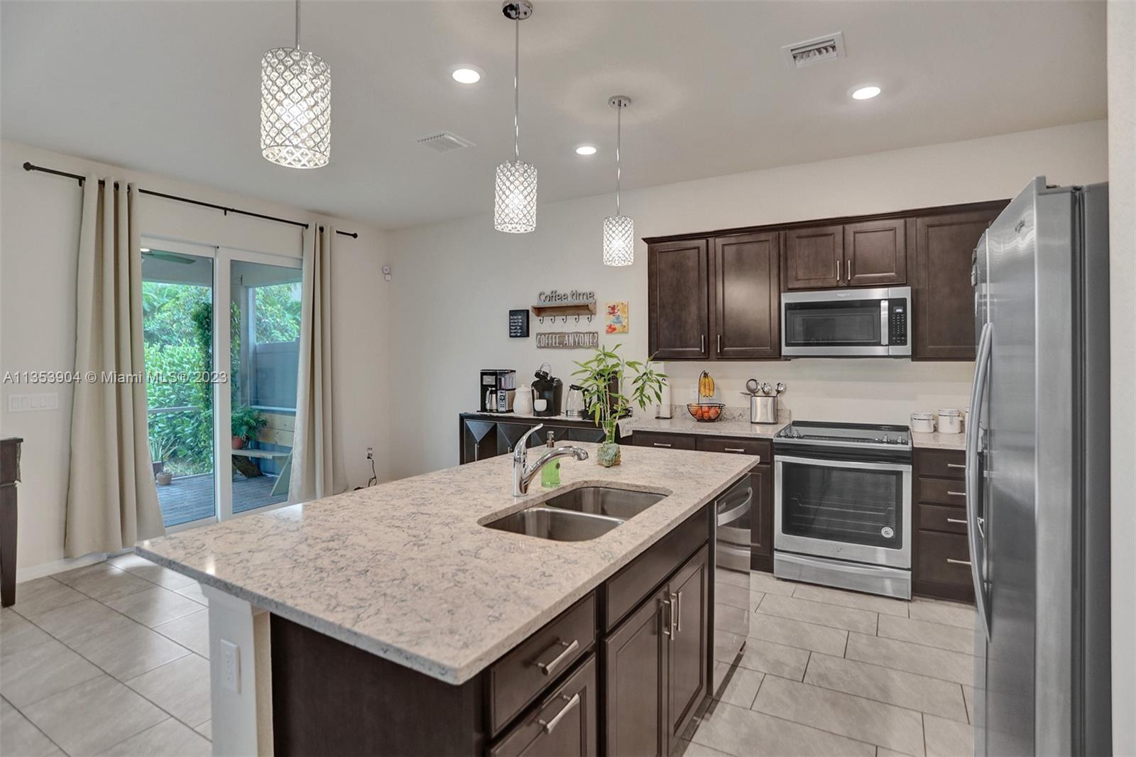 4764 Eucalyptus Drive, Unit 4764 Hollywood, FL 33021 - Photo 10 of 54 a kitchen with kitchen island a sink stainless steel appliances and a counter top space