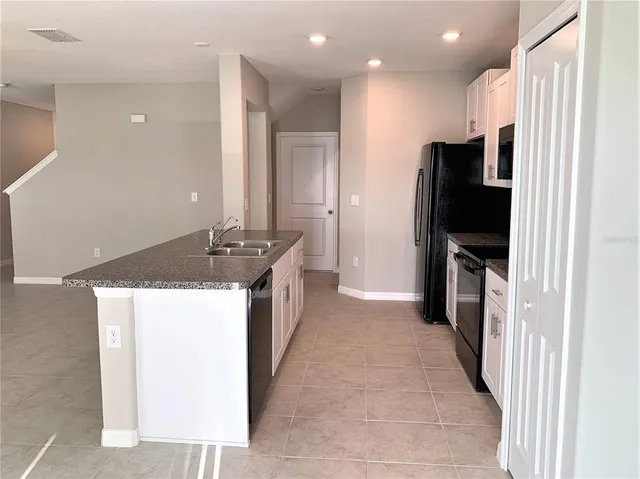 a kitchen with a sink dishwasher and a stove with wooden floor