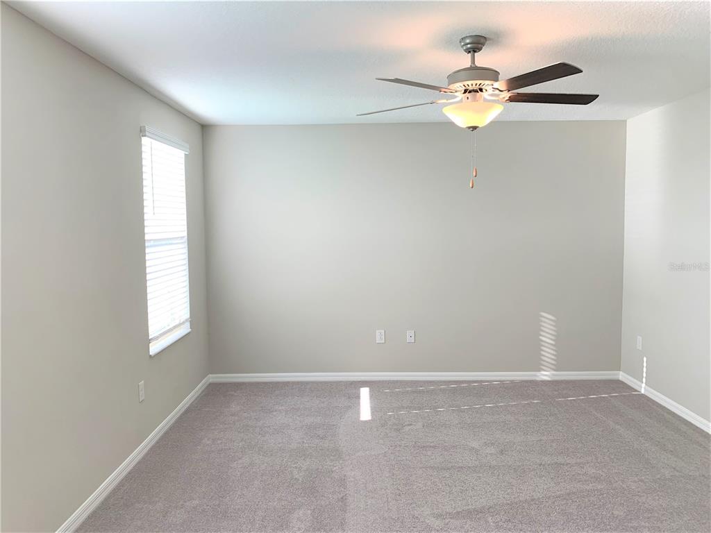 4412 Summer Savory Street Tampa, FL 33619 - Photo 16 of 40 an empty room with a window and a fan