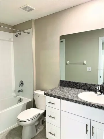 an empty room with a chandelier fan and a window