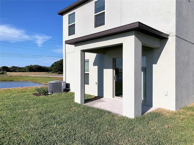 a front view of a house with a yard and lake view