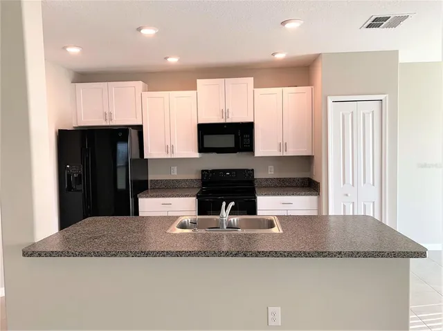 a kitchen with granite countertop a sink and a stove