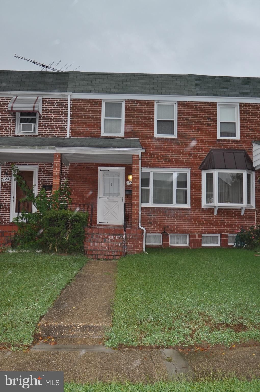 7438 Durwood Road Baltimore, MD 21222 - Photo 1 of 20 front view of a brick house with a yard