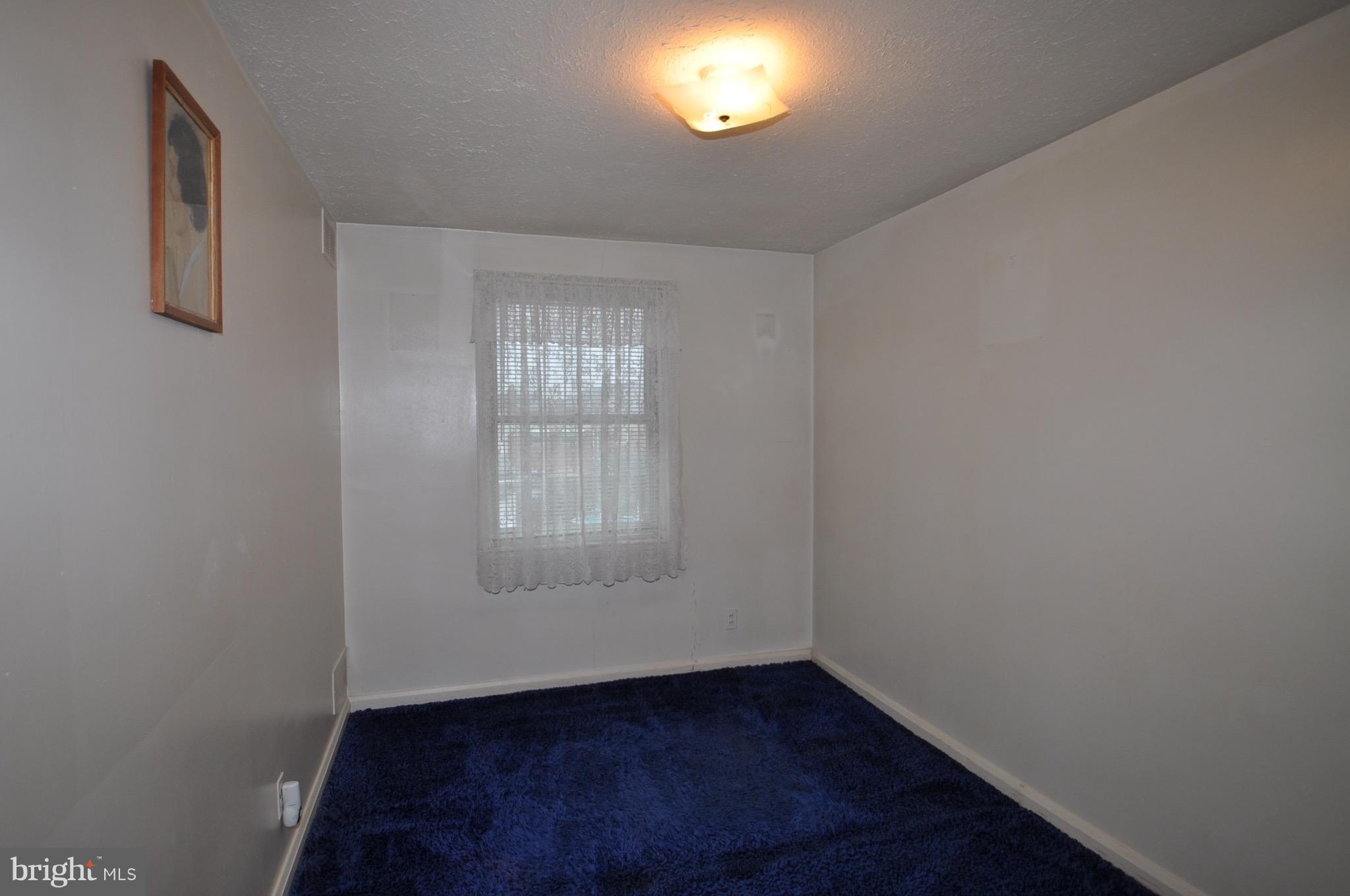 7438 Durwood Road Baltimore, MD 21222 - Photo 14 of 20 an empty room with wooden floor and windows